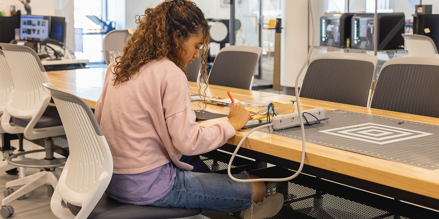 student sitting at a table in the Makerspace in the Library at the Parr Center of Central Piedmont