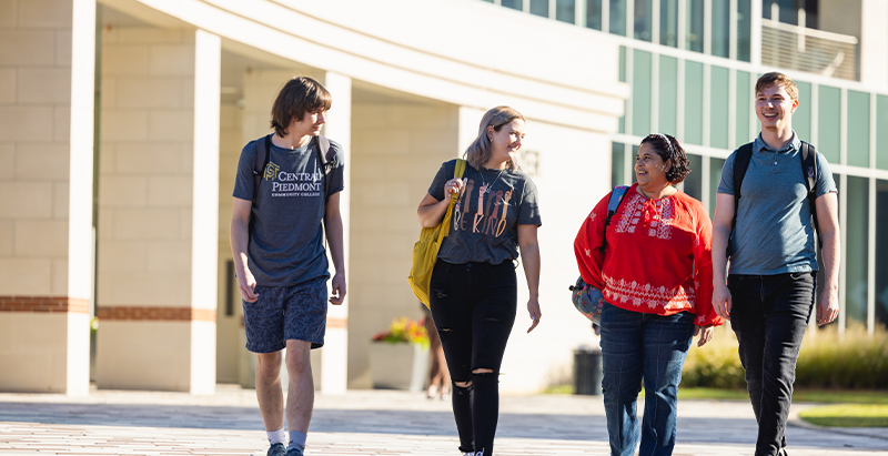 Four students walking pass Parr center