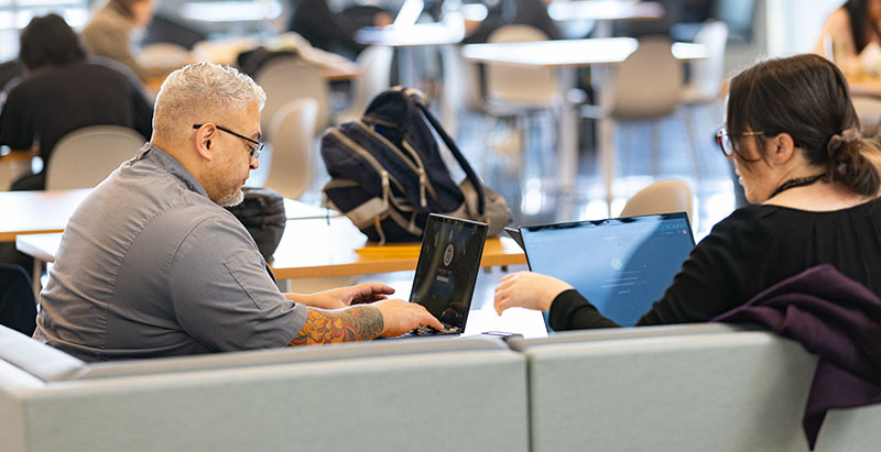 two students in front of laptops in Parr Center at Central Piedmont