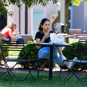 A student sitting outdoors on Central Piedmont's Central Campus on the first day of class