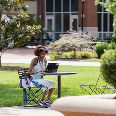 Student with laptop on the green 