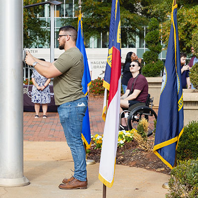 Veterans Day ceremony with flags outside with Military Families and Veterans students and staff