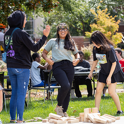 Three students playing games on the green