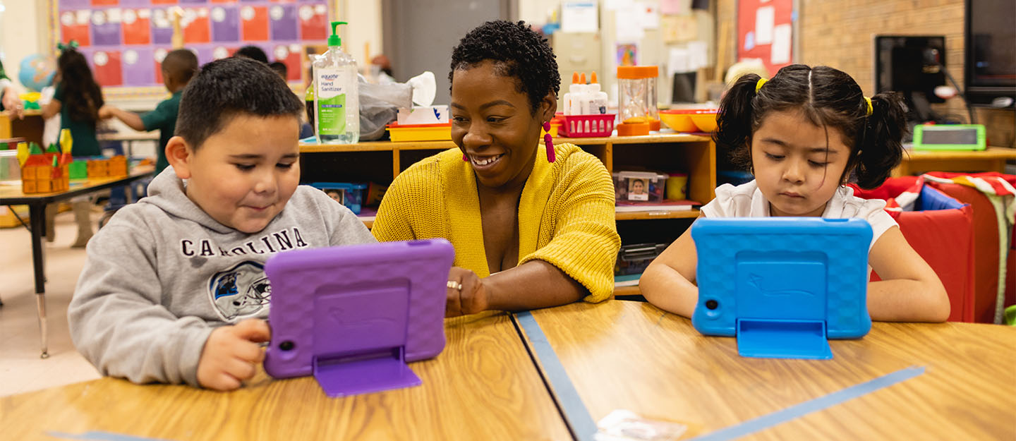 A teacher with two young students working on tablets at Central Piedmont