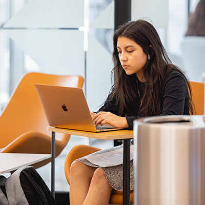student on laptop in the Library on Central Campus
