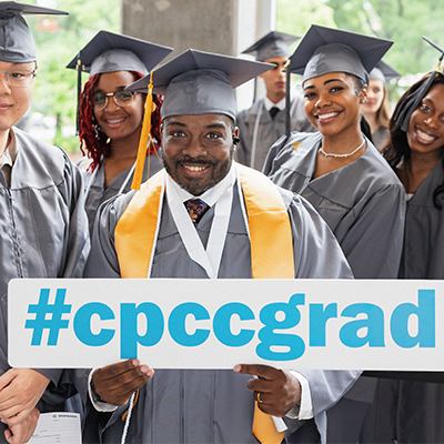 A Central Piedmont student holding a sign that says #cpccgrad