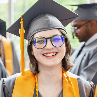 A Central Piedmont student smiling in cap and gown