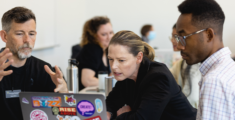 Three people looking quizzically at a computer