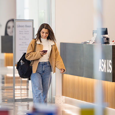 student walking in front in Hagemeyer Library at Parr Center