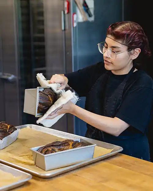hospitality, culinary, and baking student pulling bread out of the pain
