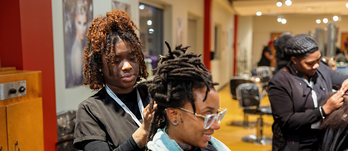 Cosmetology student retwisting dreads 
