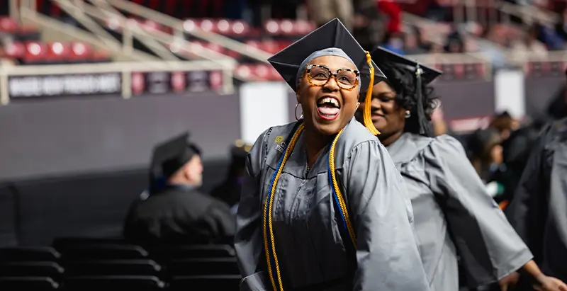 A happy Central Piedmont graduate at the December 2024 commencement ceremony