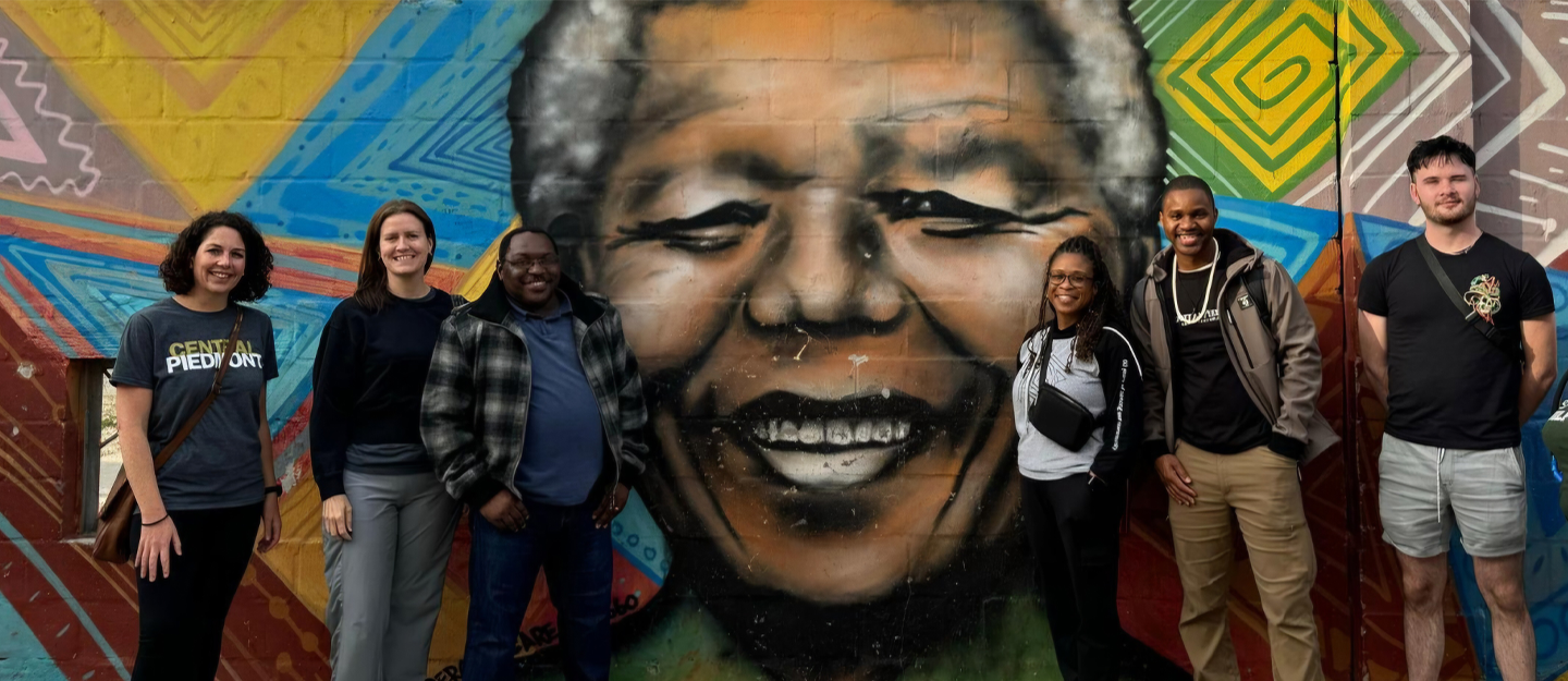 Study Abroad students standing in front of a mural 