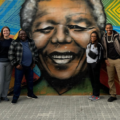 Study Abroad students standing in front of a mural on a trip 