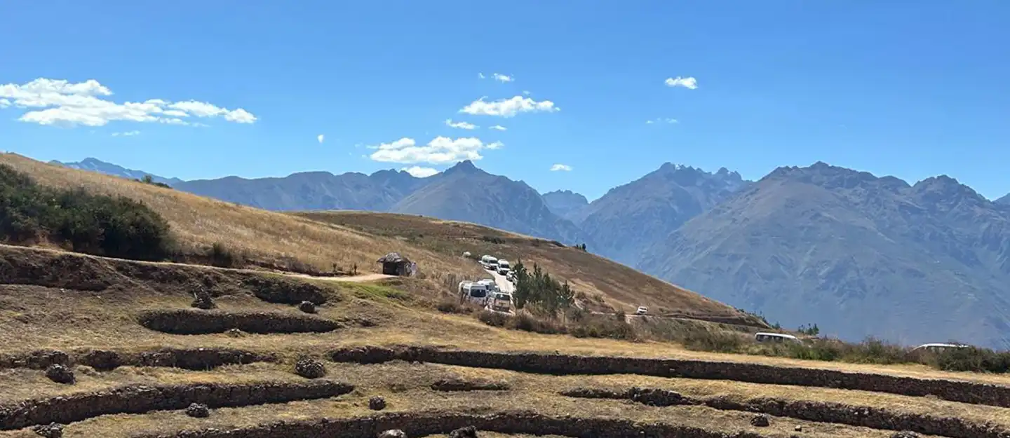 A view of Cusco, Peru, with blue skies and mountains in the distance