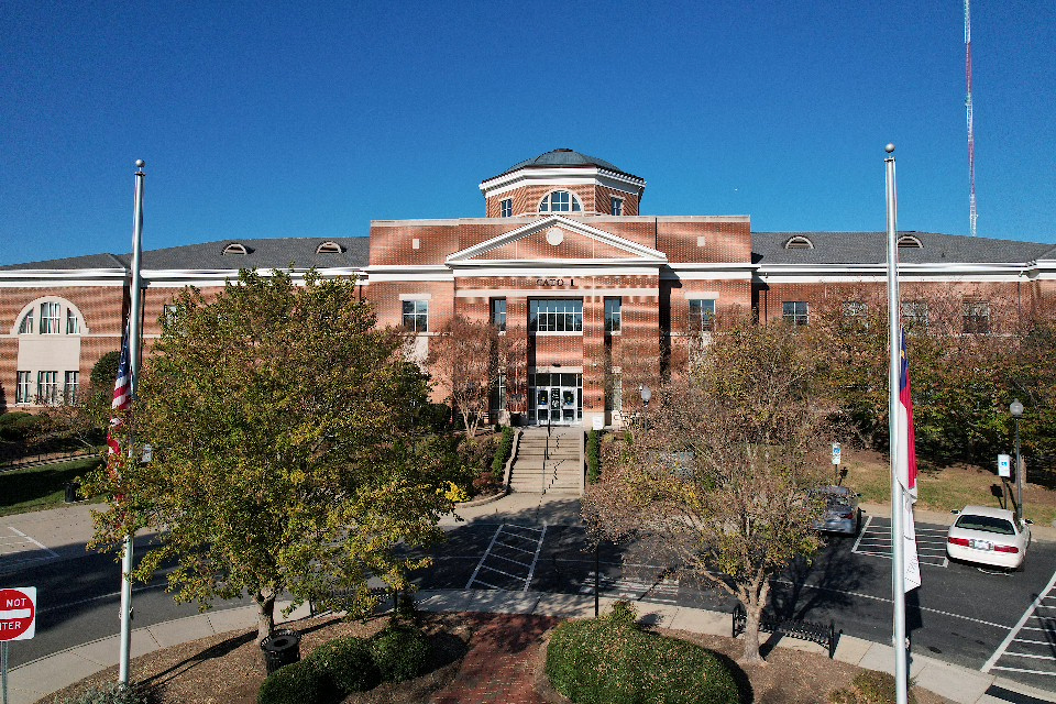 Cato Campus main building, a red-brick hall with a white cupola and flagpoles at the entrance