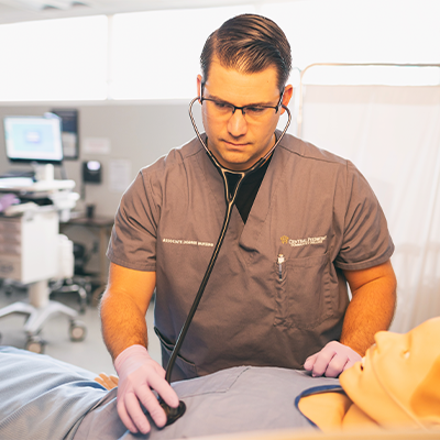 Nurse aide student using a stethoscope to check a patient