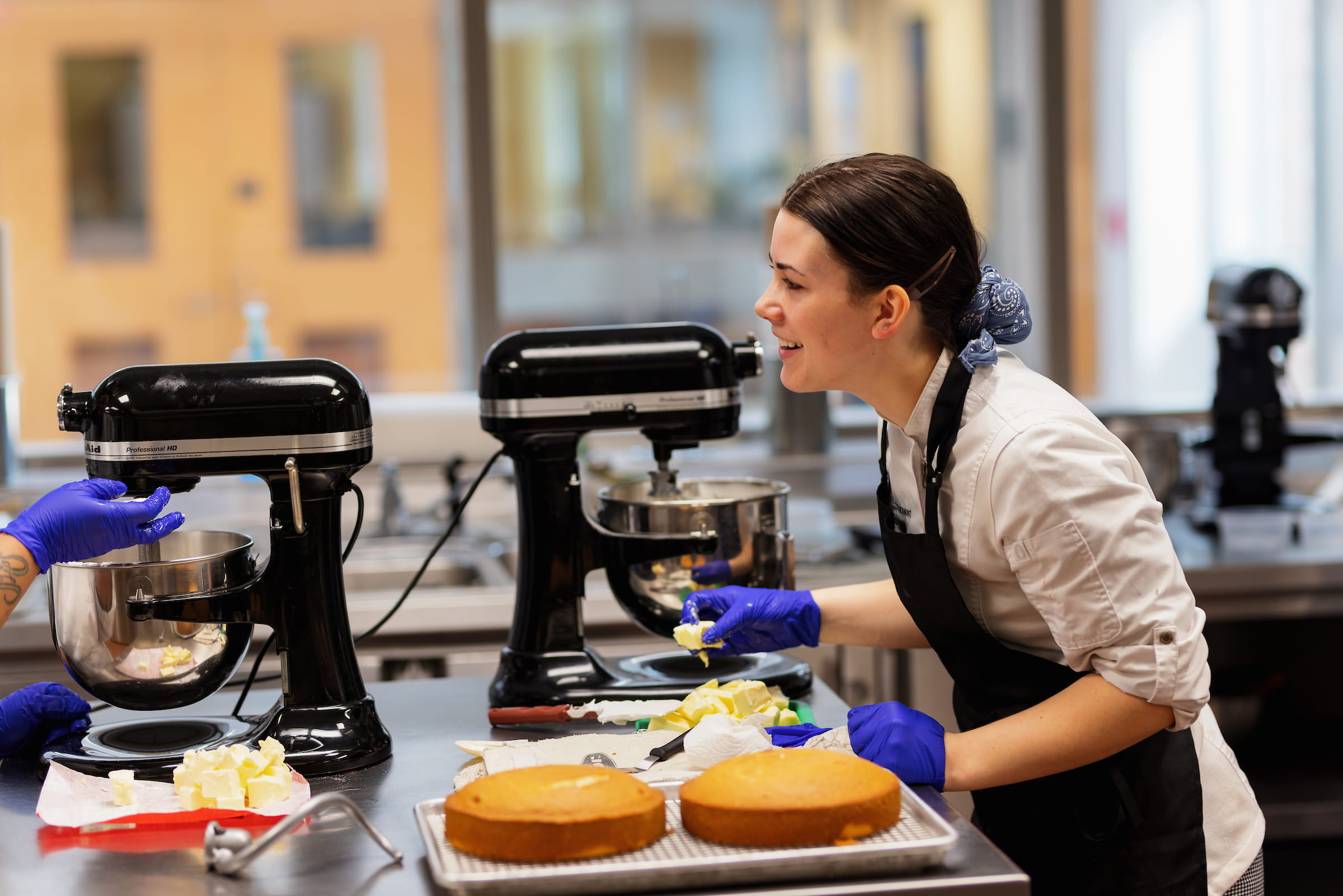 Baking and pastry student working with stand mixers and cake layers