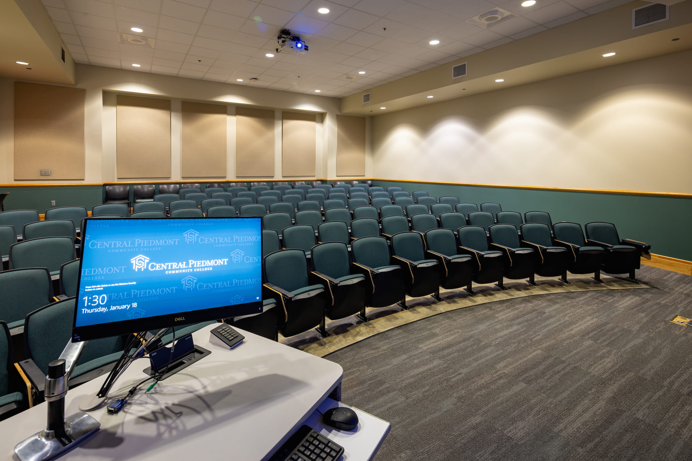 Tiered lecture auditorium with a presentation screen at the front