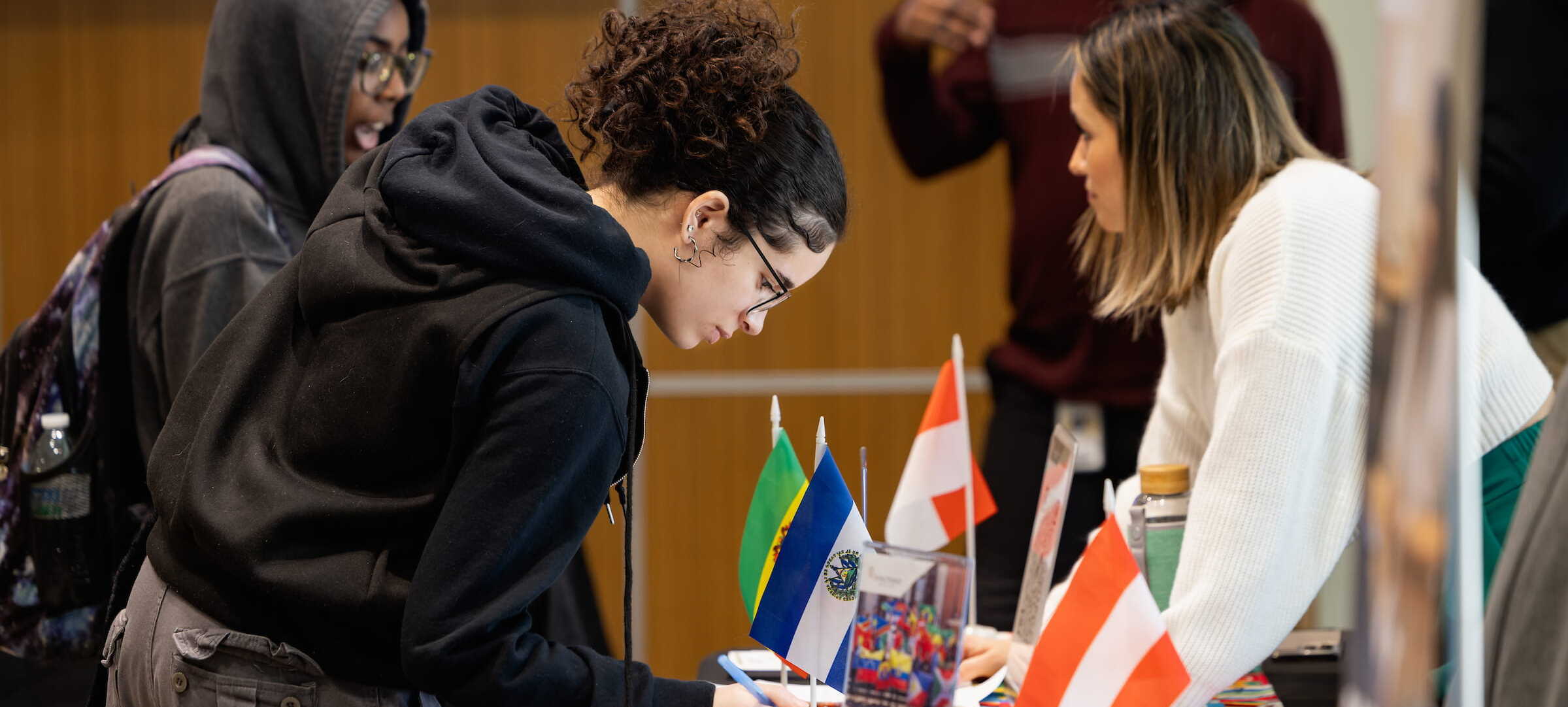 Students at a table displaying international flags