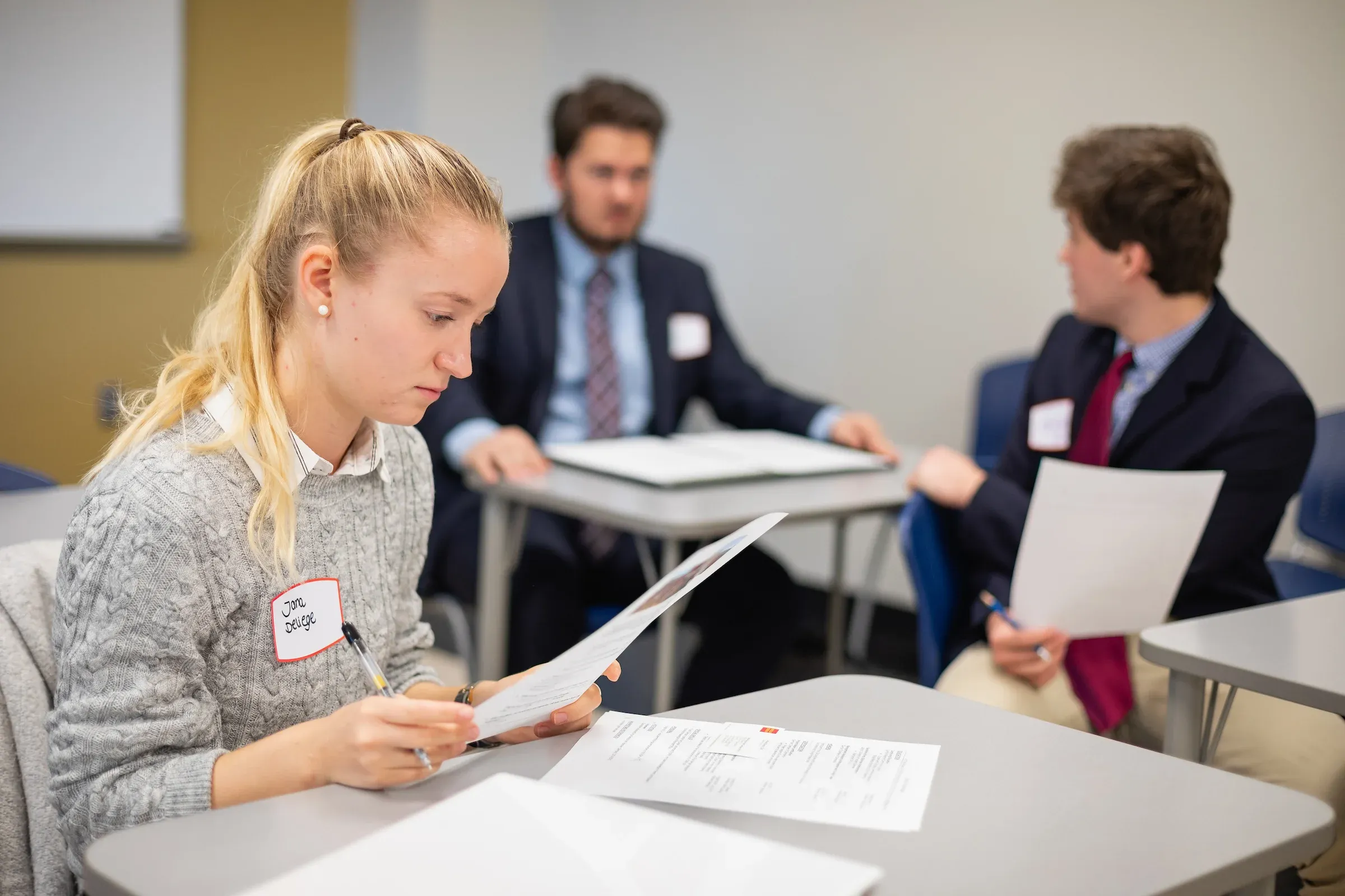 Student reviewing printed results at a table during an event