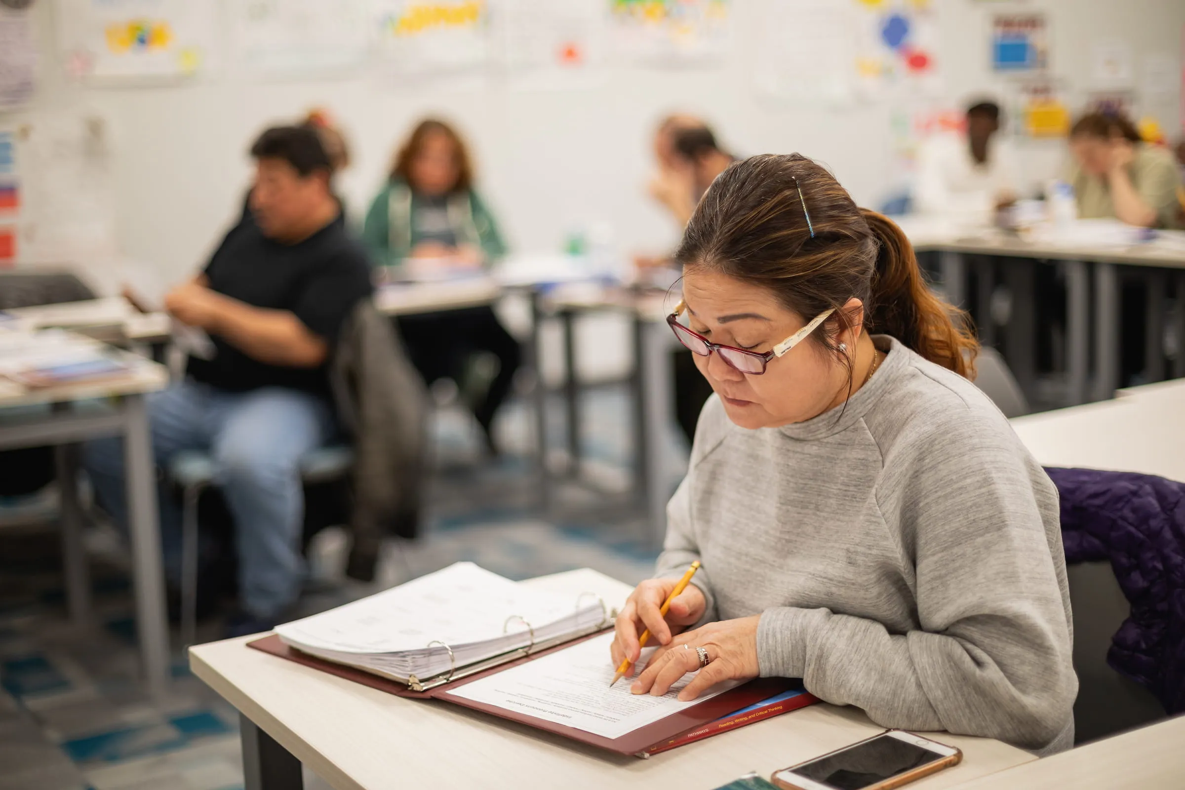 Student writing in a notebook during class