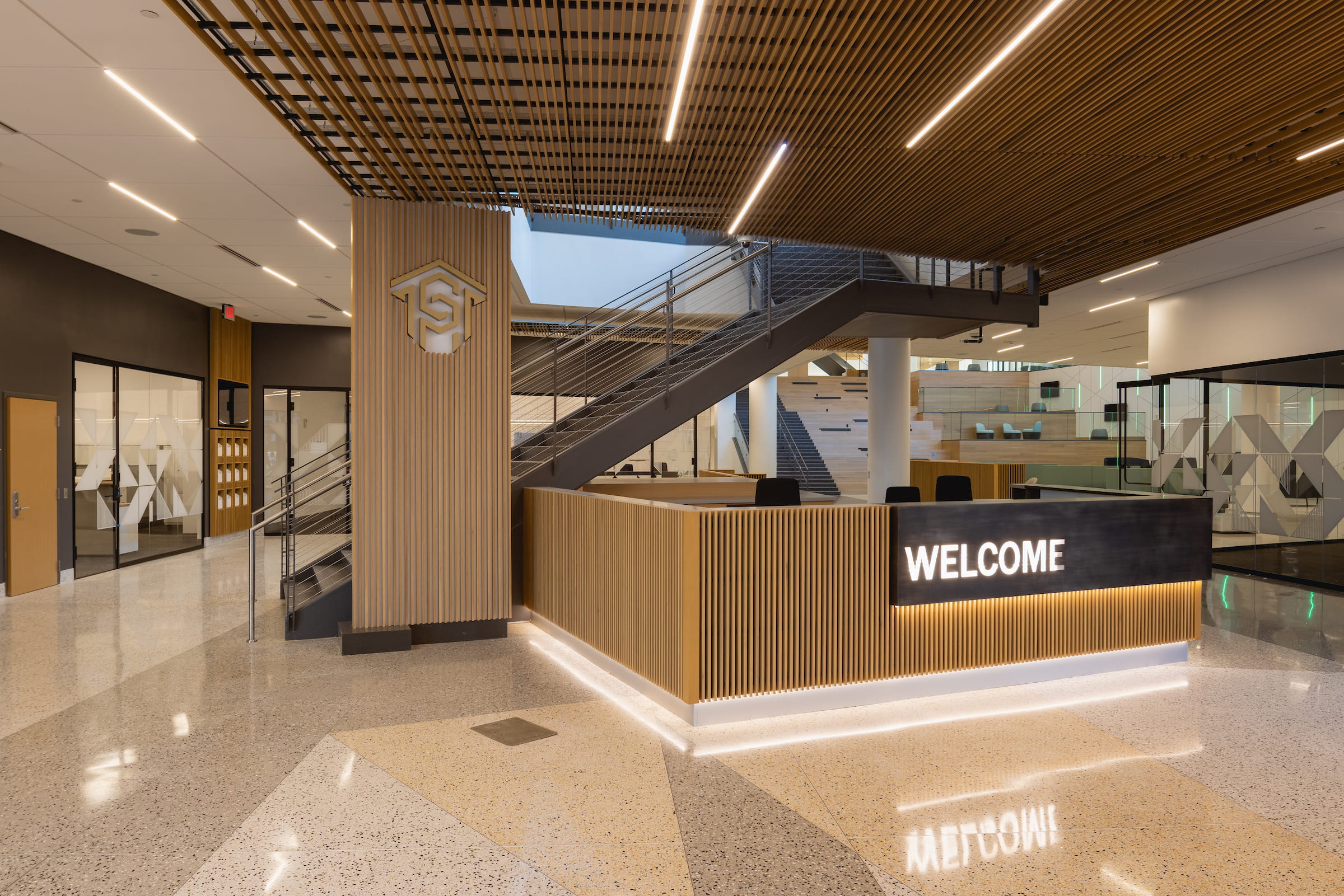 Welcome Center lobby with a wood-slatted ceiling, open staircase and reception desk