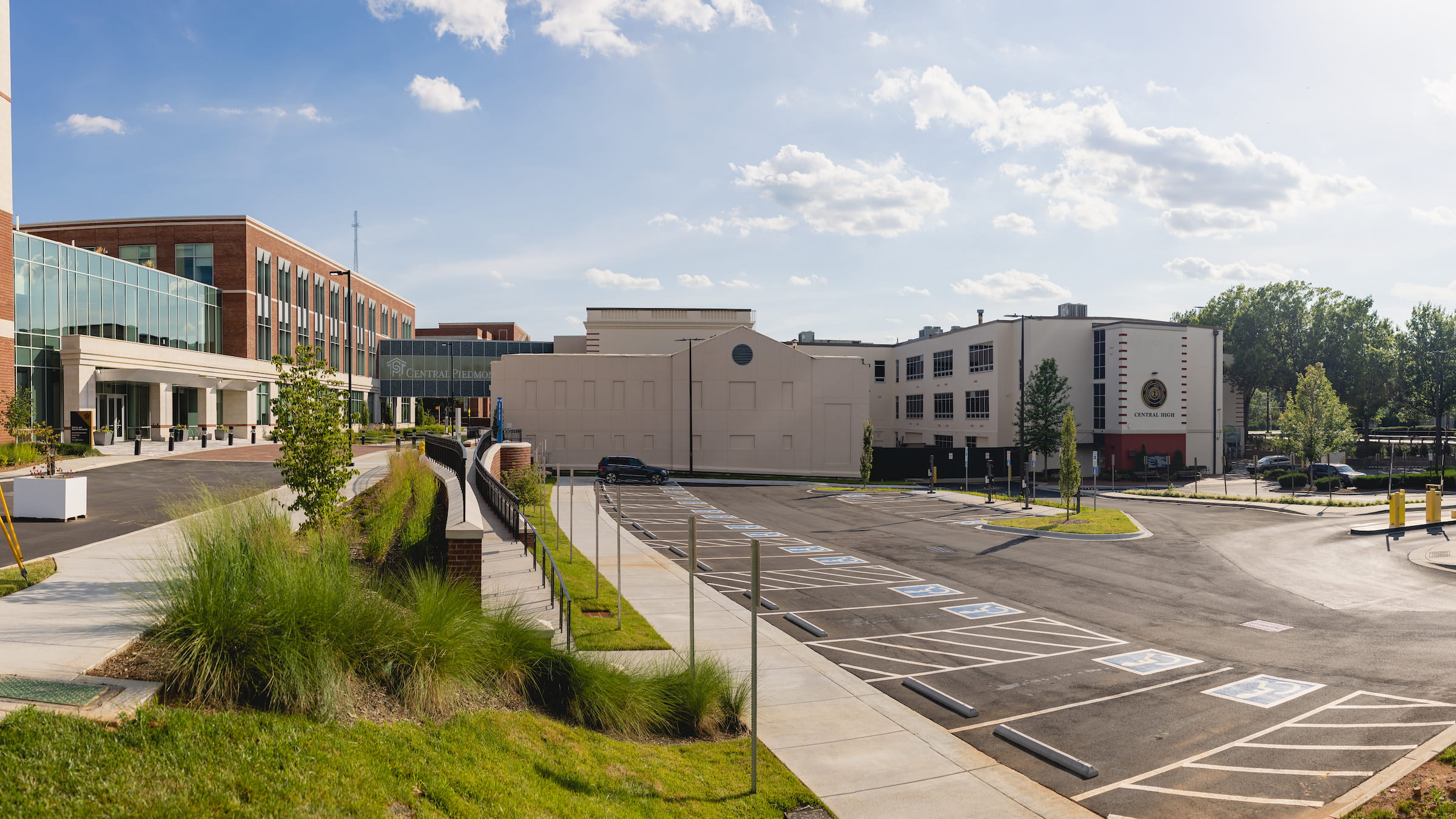 Campus parking lot beside college buildings under a clear sky