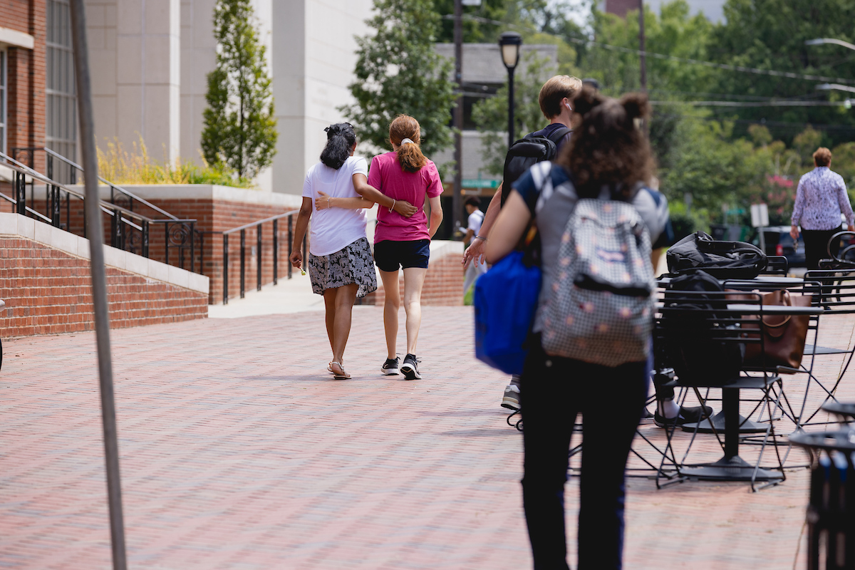 Students walking with their arms around each other on Central Campus.
