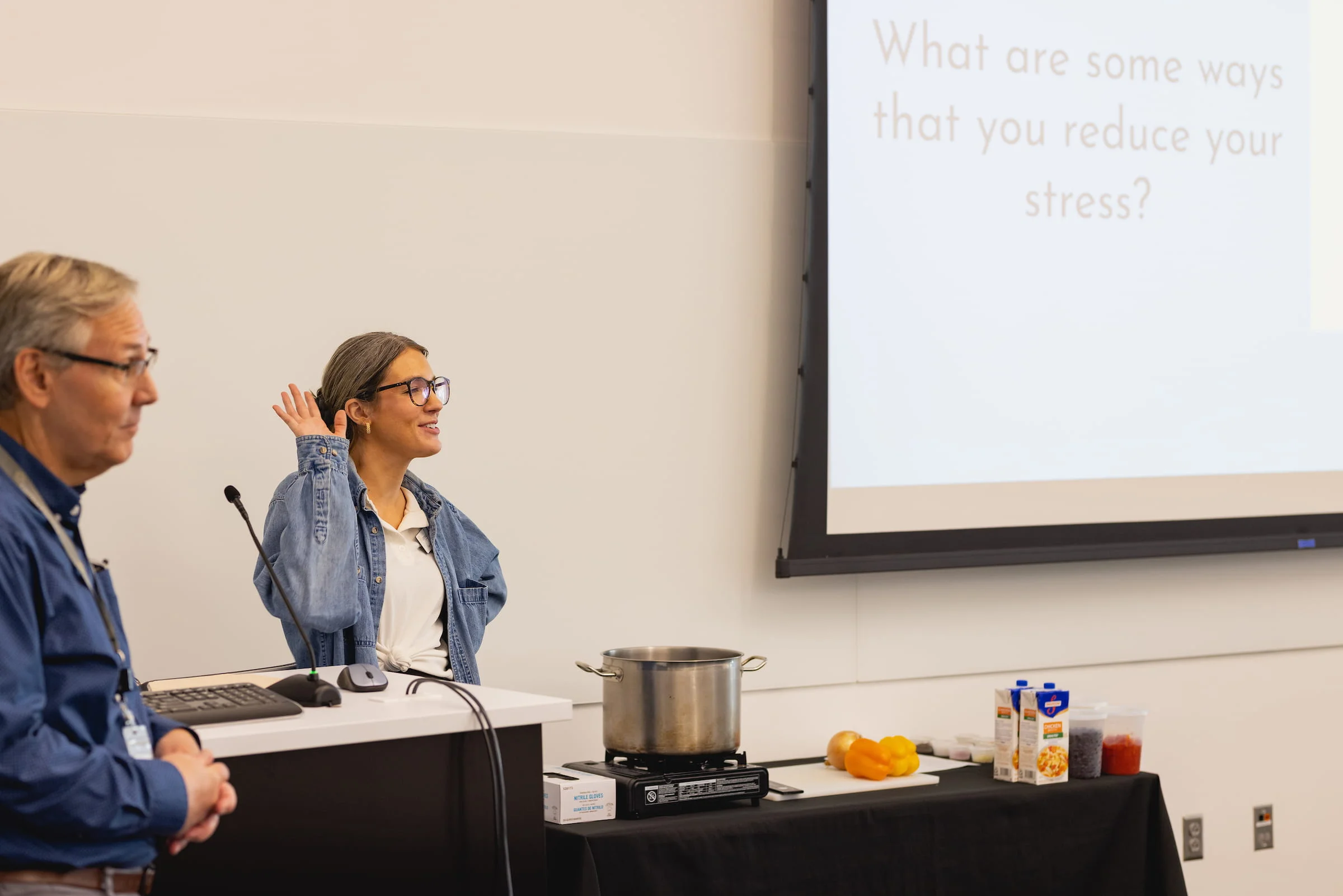 Presenter leading a stress management workshop beside a projected question