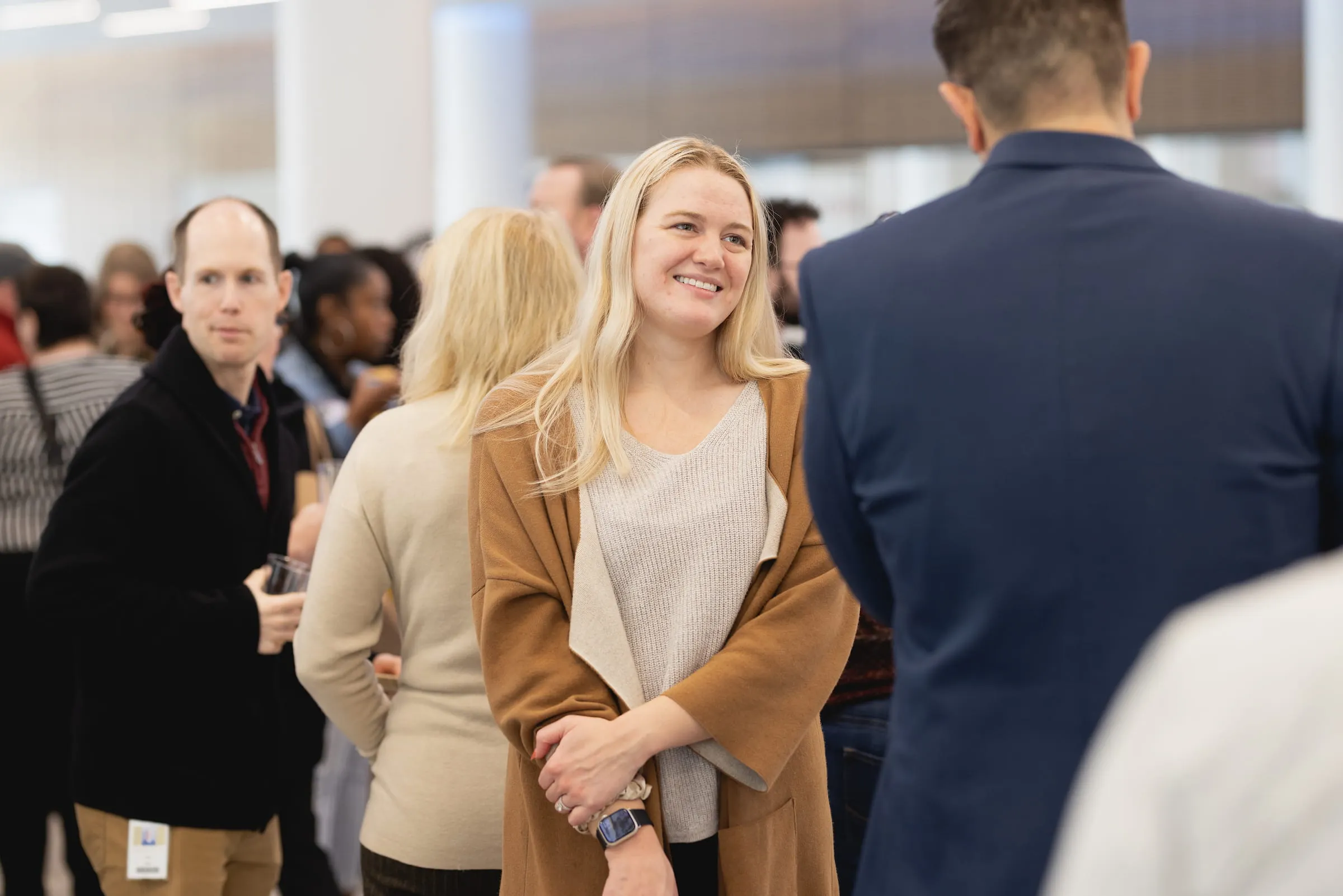 Alumna smiling among guests at a networking event