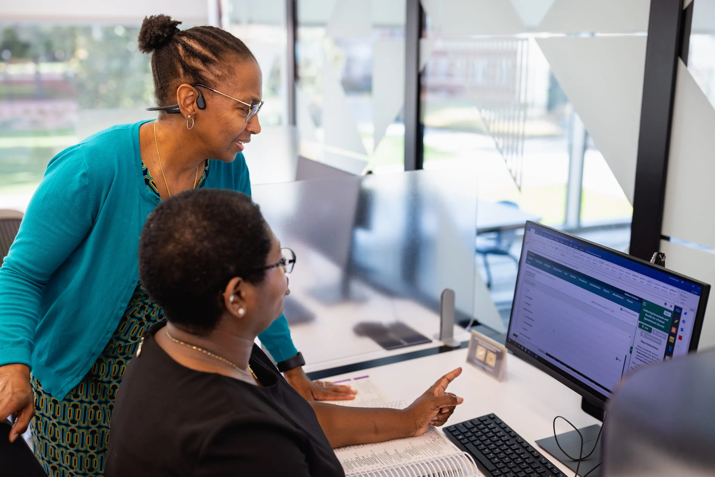 Staff member helping a student at a computer