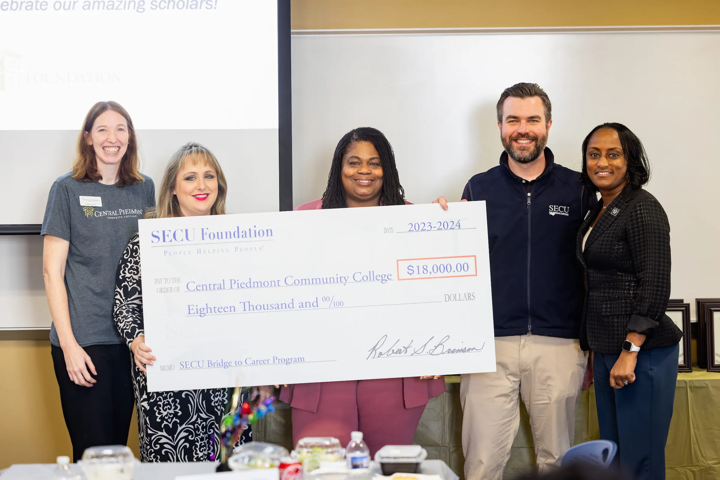 Staff and students holding a large ceremonial cheque from the SECU Foundation