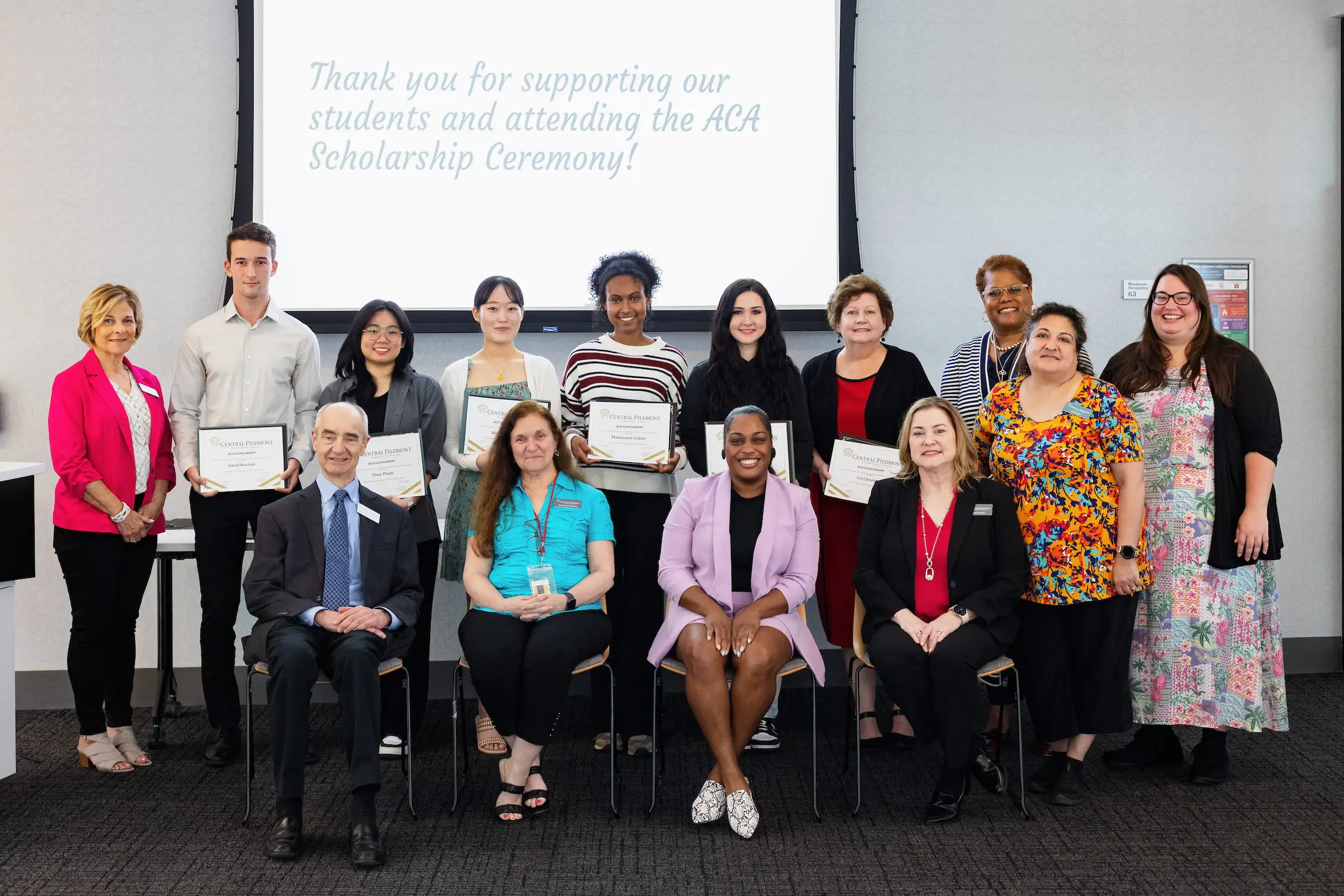 Scholarship recipients posing with certificates at the awards ceremony