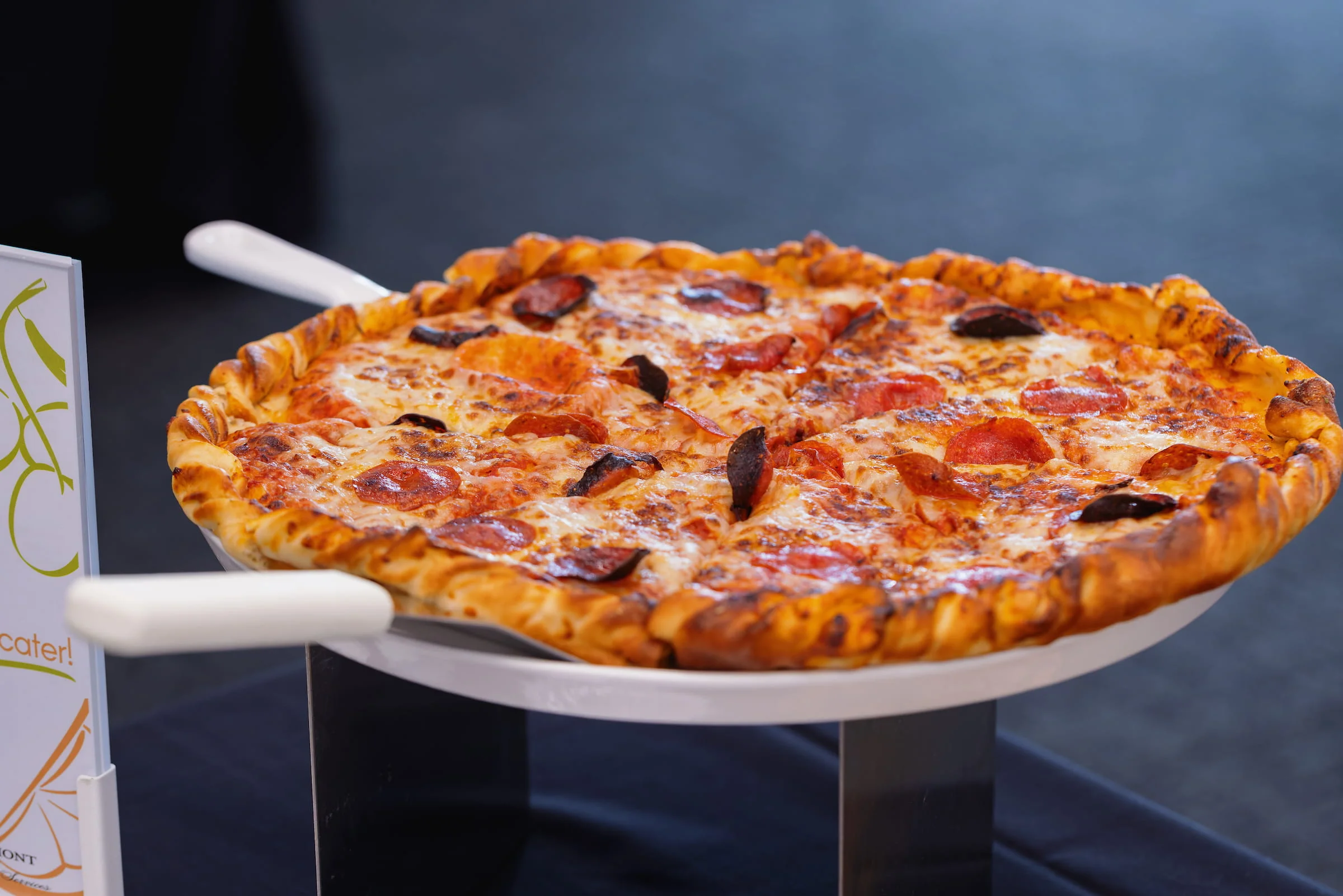 Whole pepperoni pizza on a serving stand