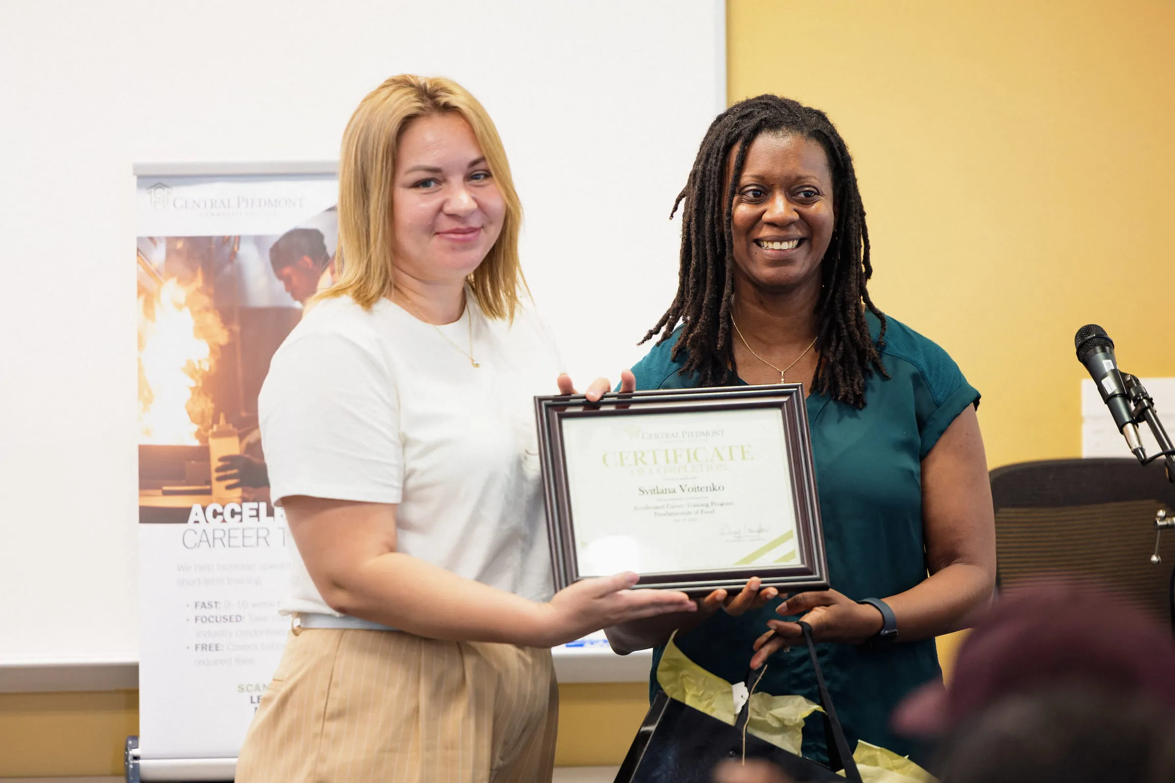 Graduate receiving a framed certificate at an awards presentation