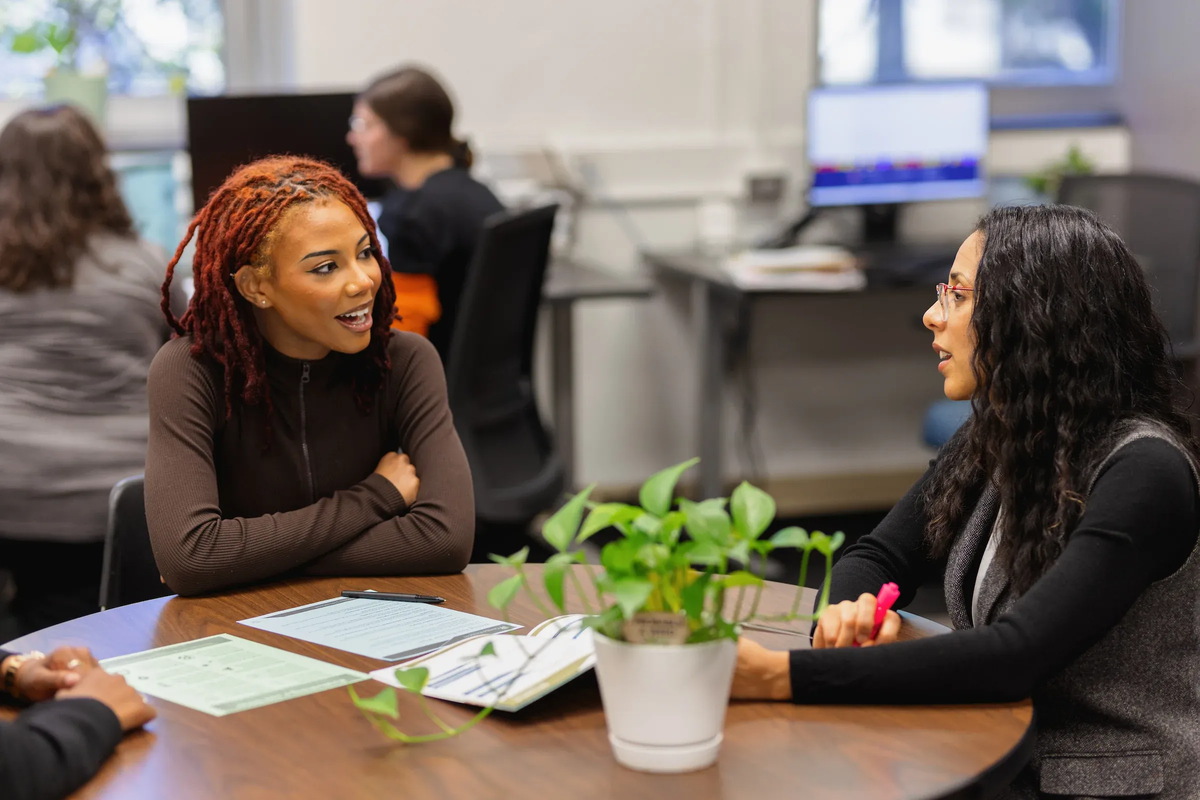 Adviser and student talking across a table in an office