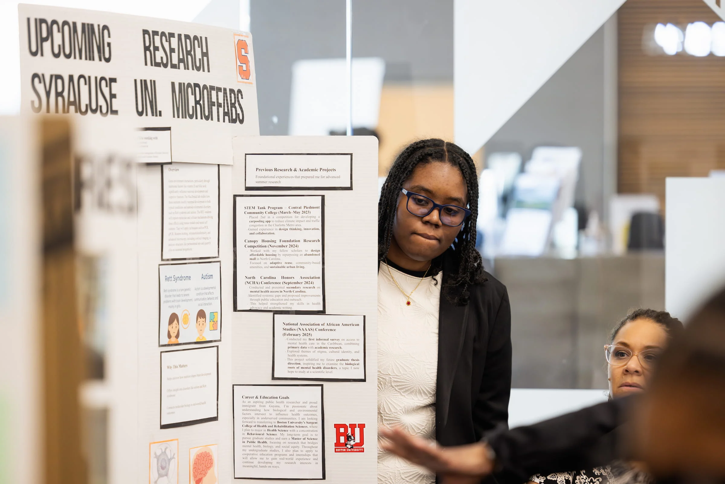 Student reading research notices on a library display board
