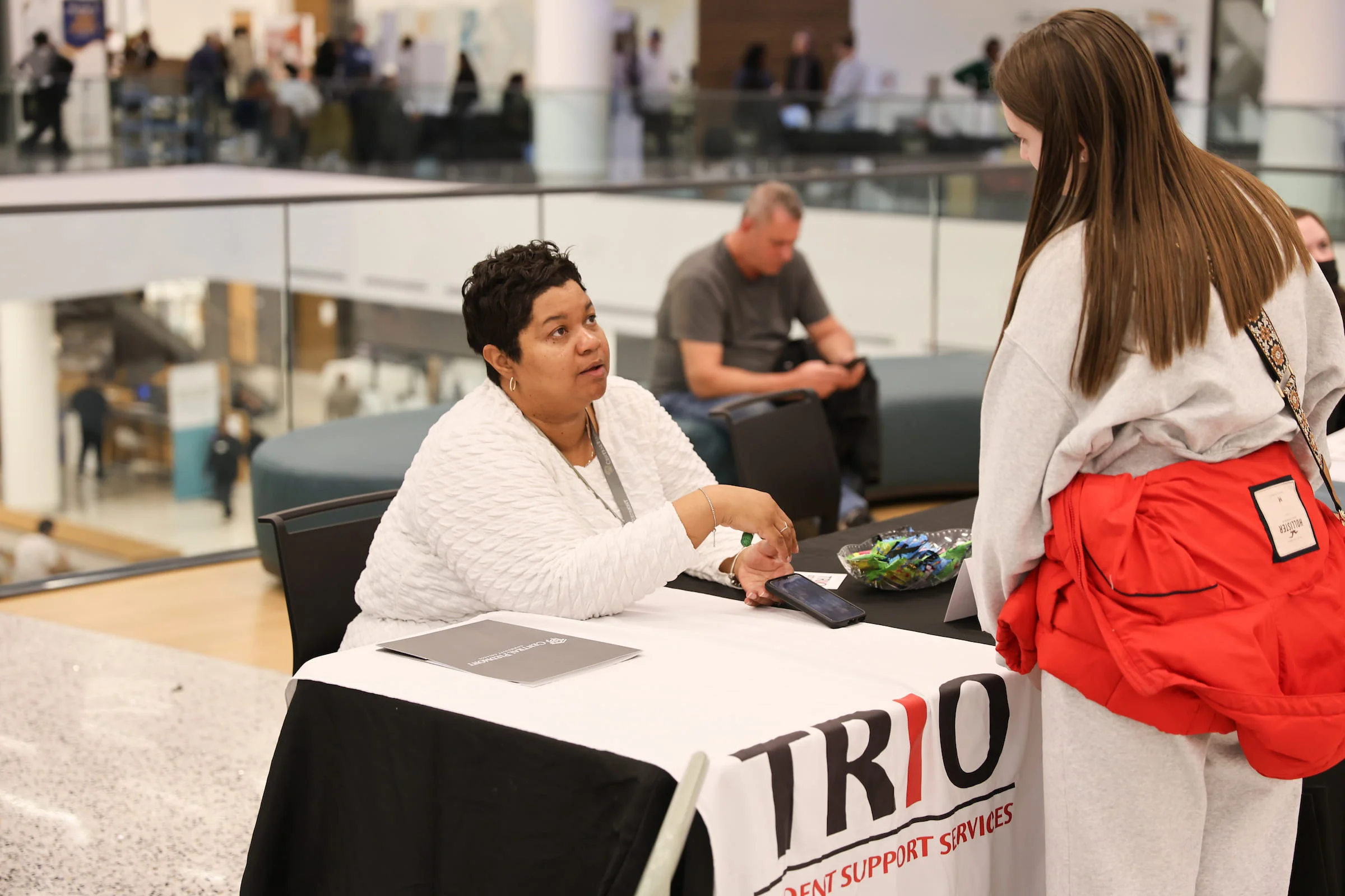 Staff member talking with a student at the TRIO Student Support Services table