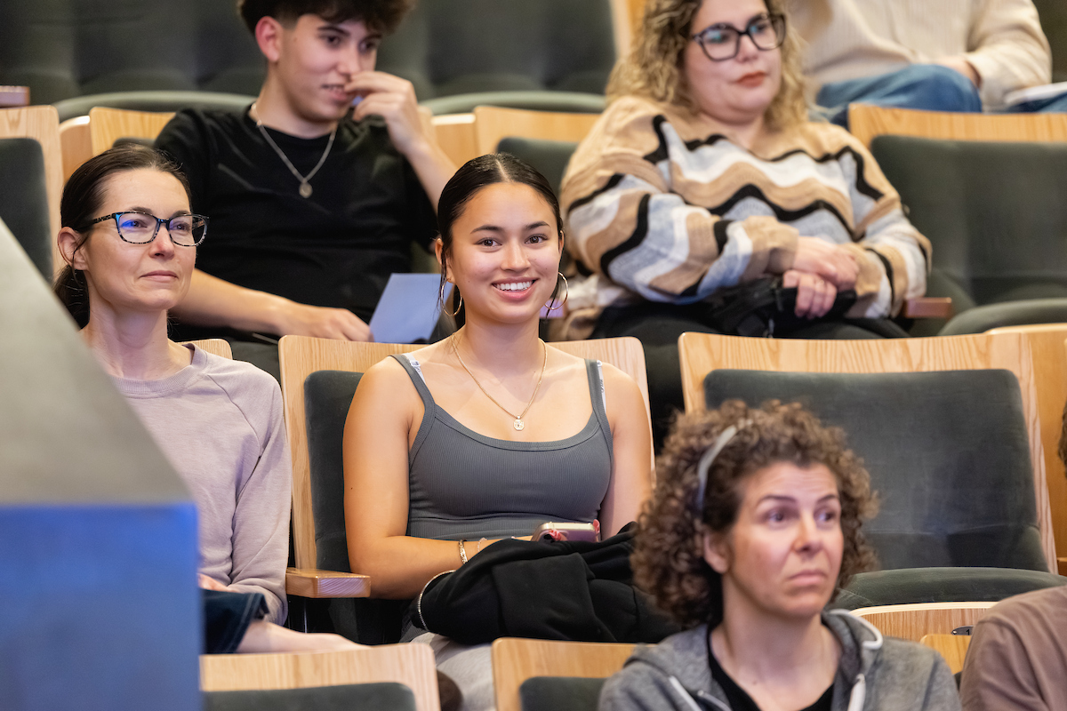 Student smiling while seated in an auditorium