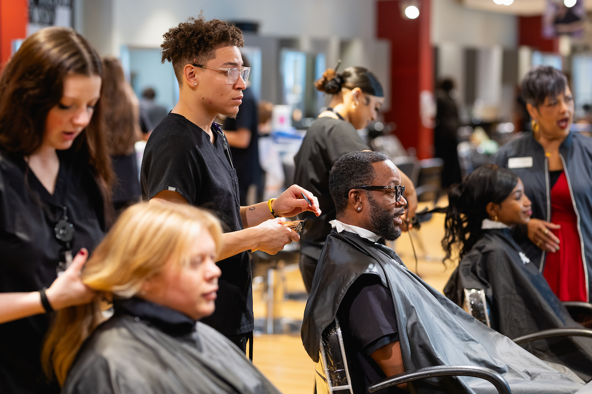 Cosmetology students preparing to give haircuts.