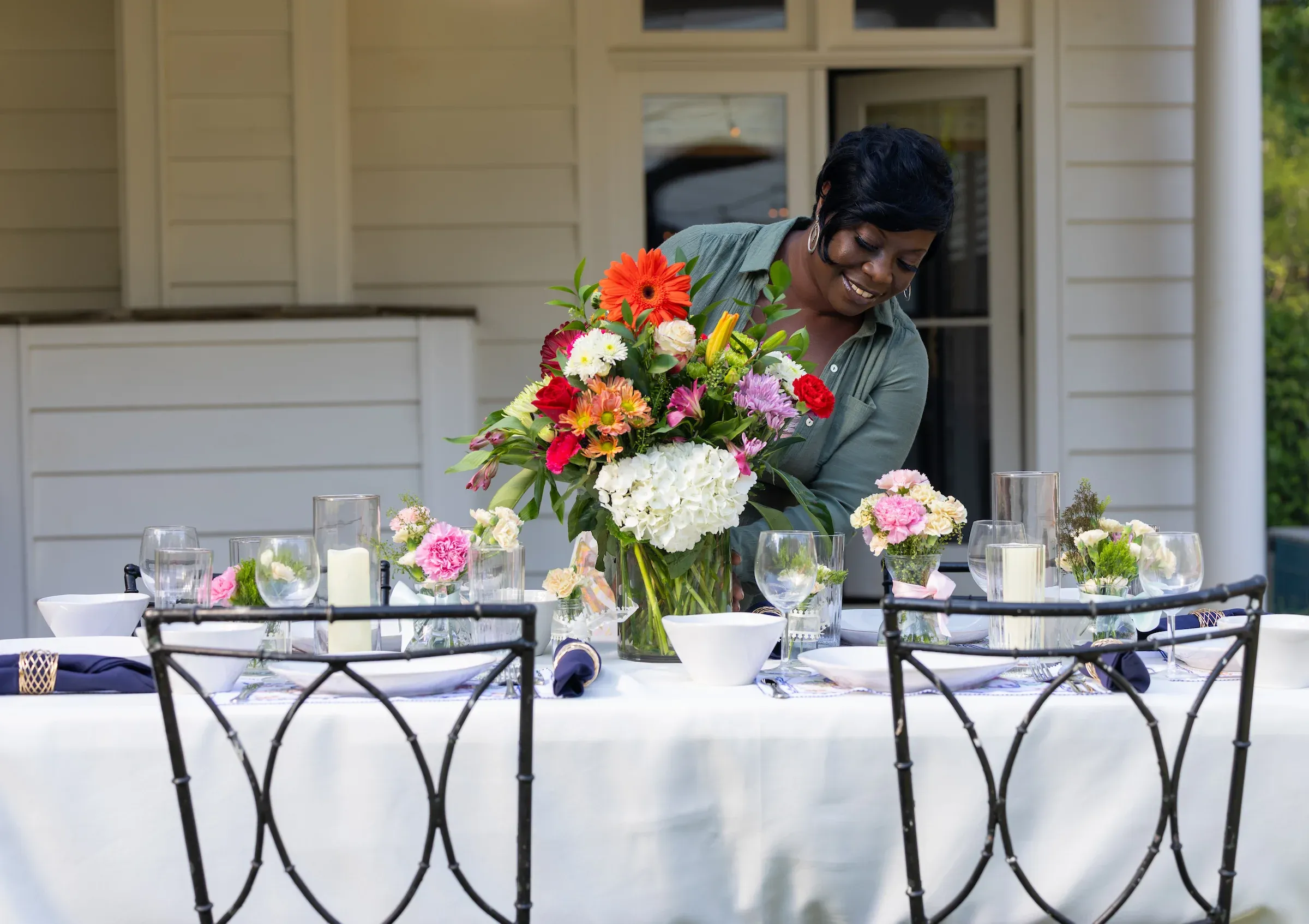 Staff member arranging flowers on a set banquet table