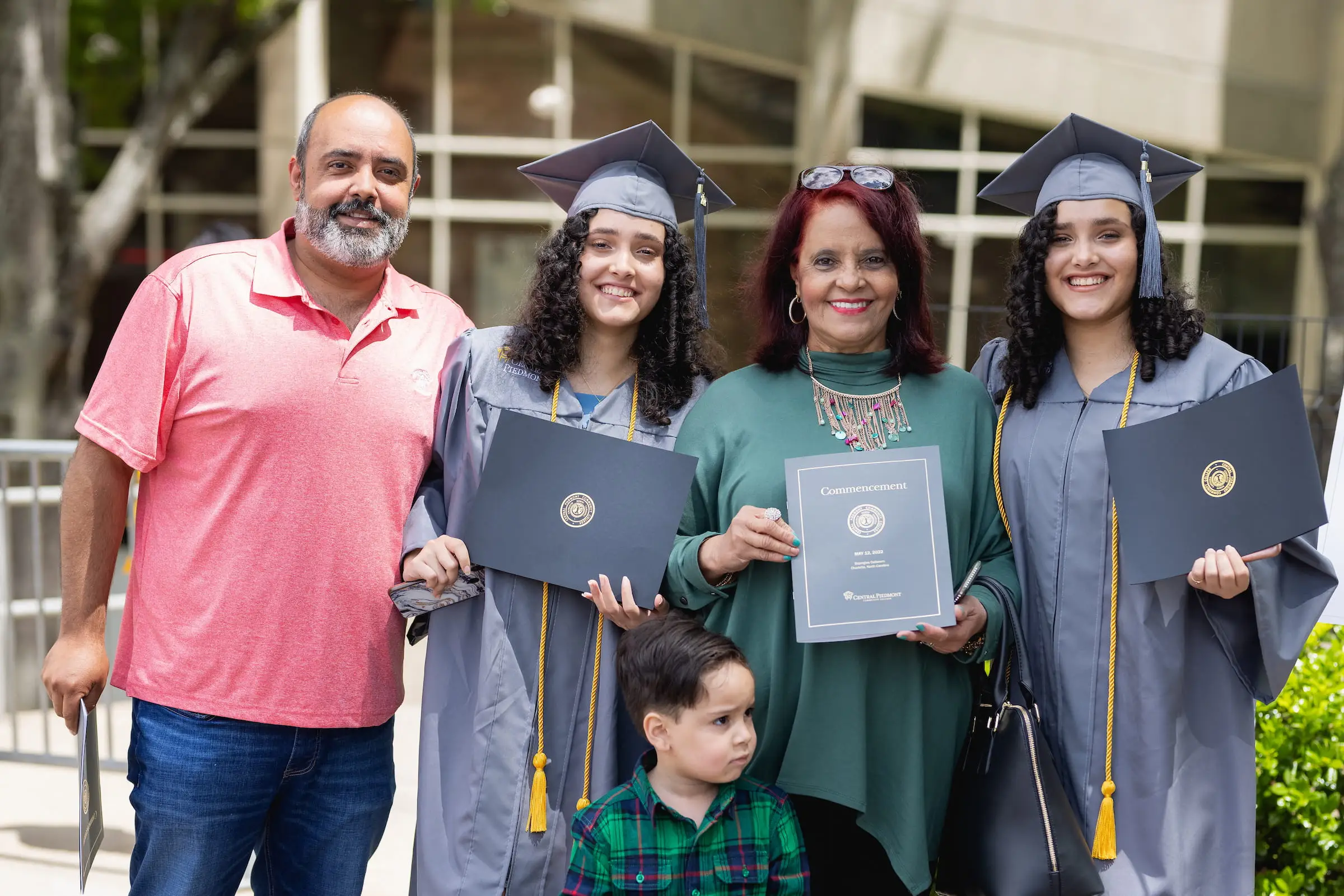 Family celebrating with graduates holding their diplomas