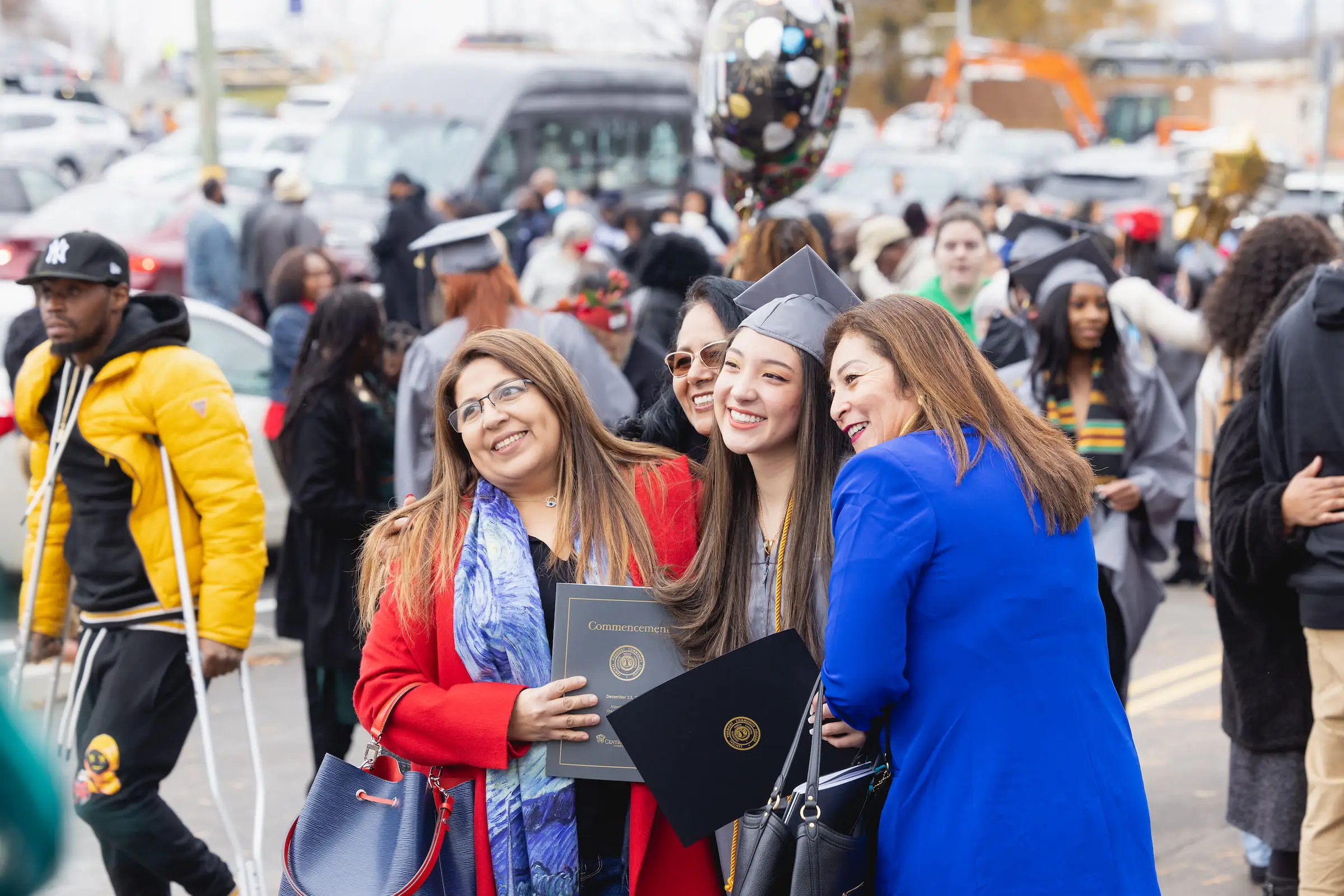 Graduates celebrating with family outdoors after the ceremony