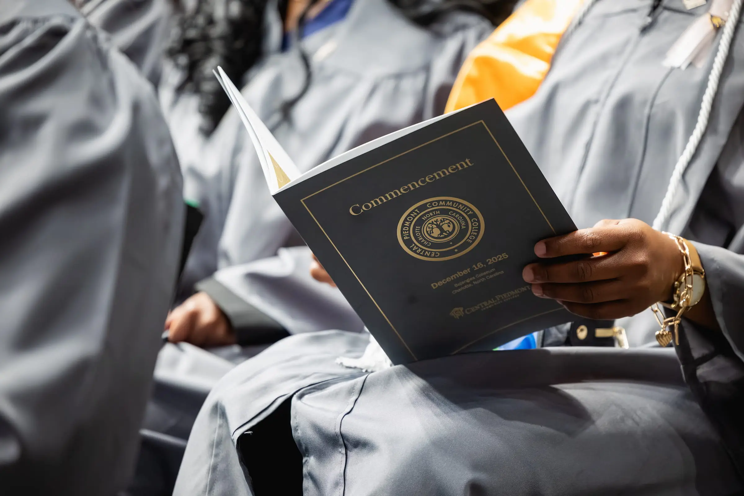 Graduate holding an open commencement programme