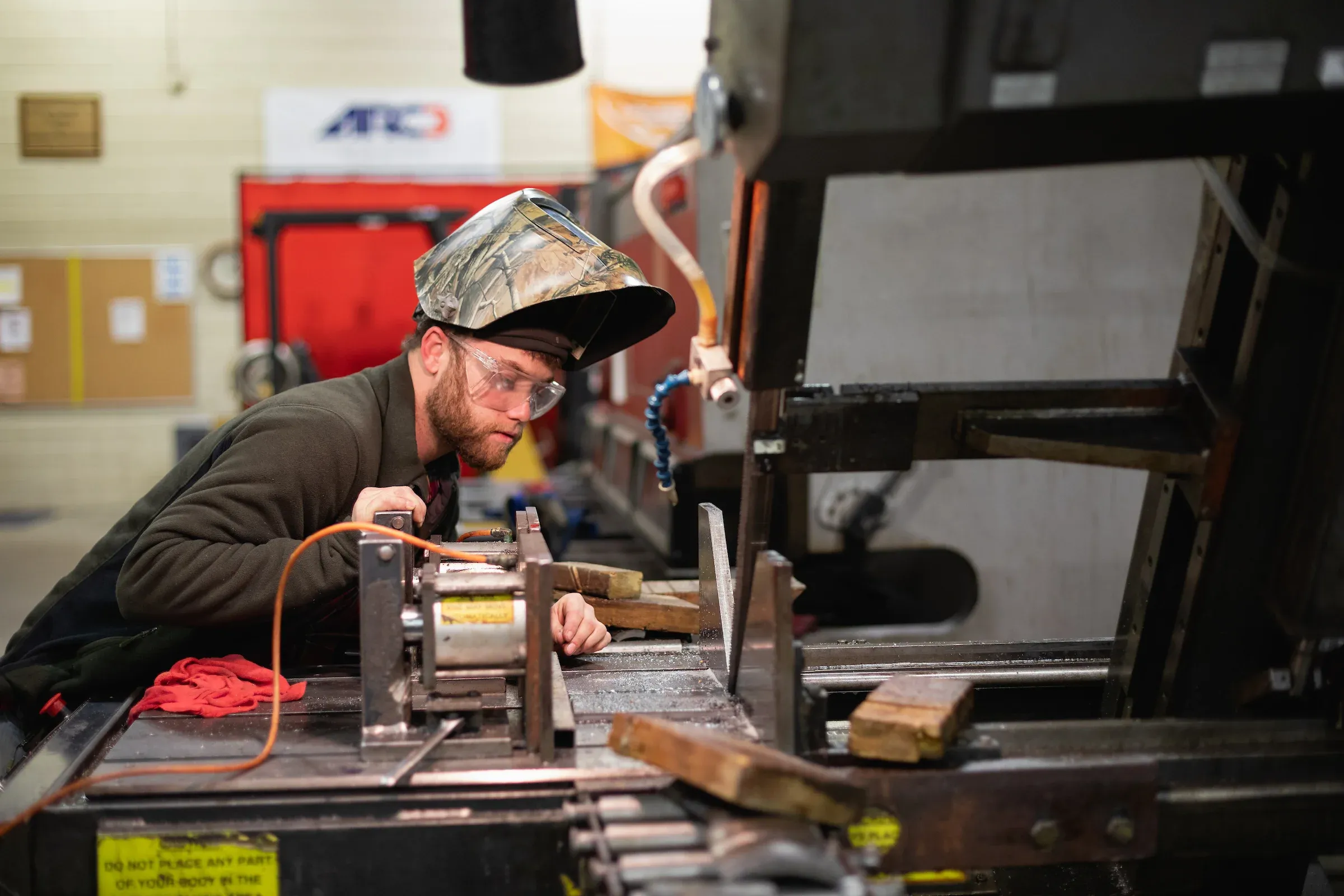 Student operating a metalworking machine while wearing a face shield