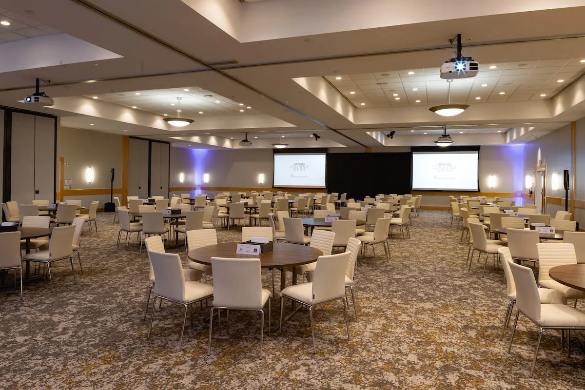 Banquet room set with round tables and presentation screens