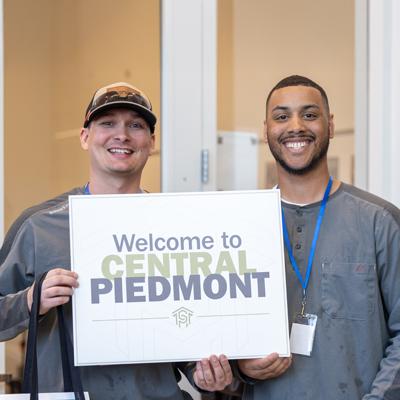 Two Central Piedmont students holding a welcome sign