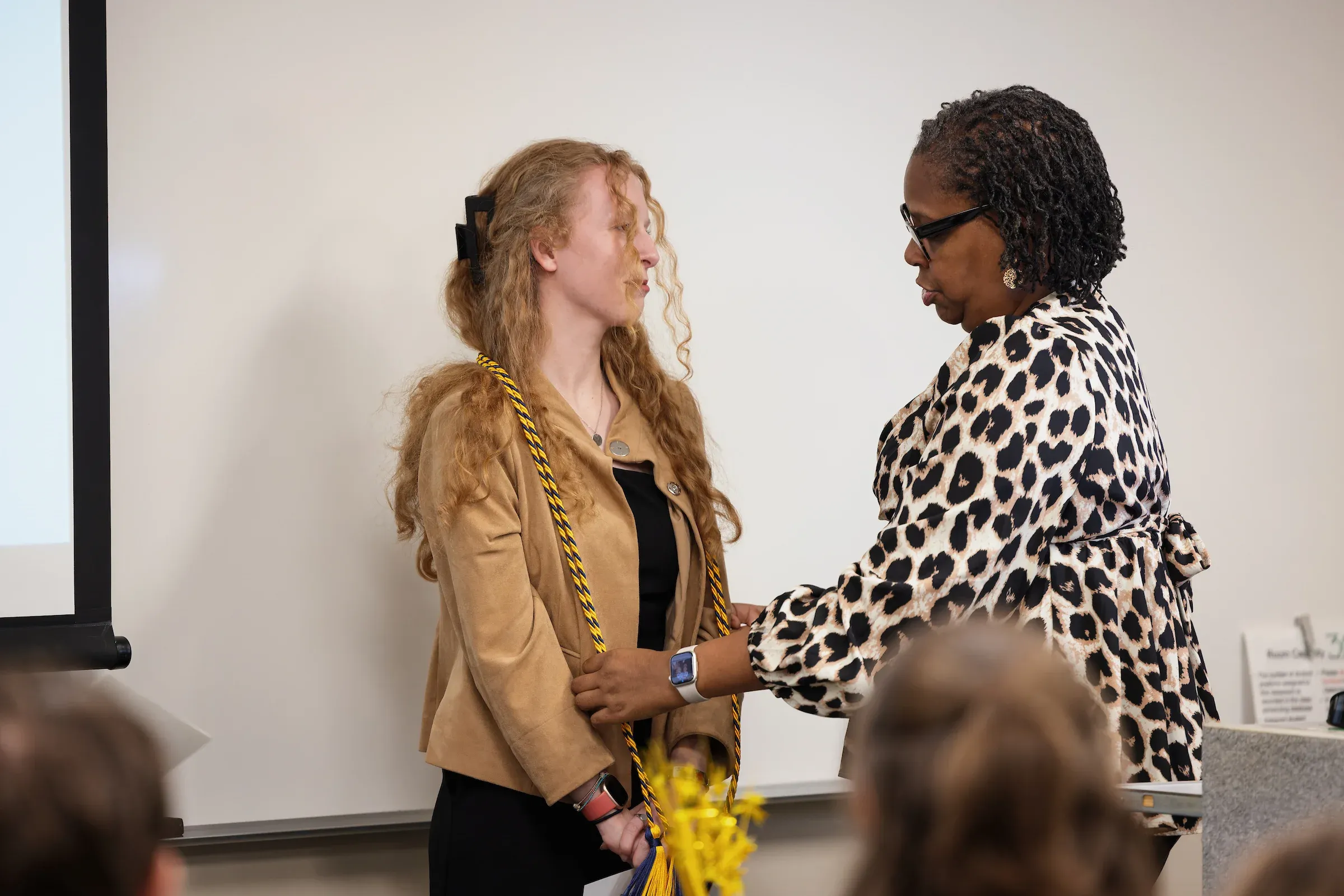 Student shaking hands with a staff member at an information event