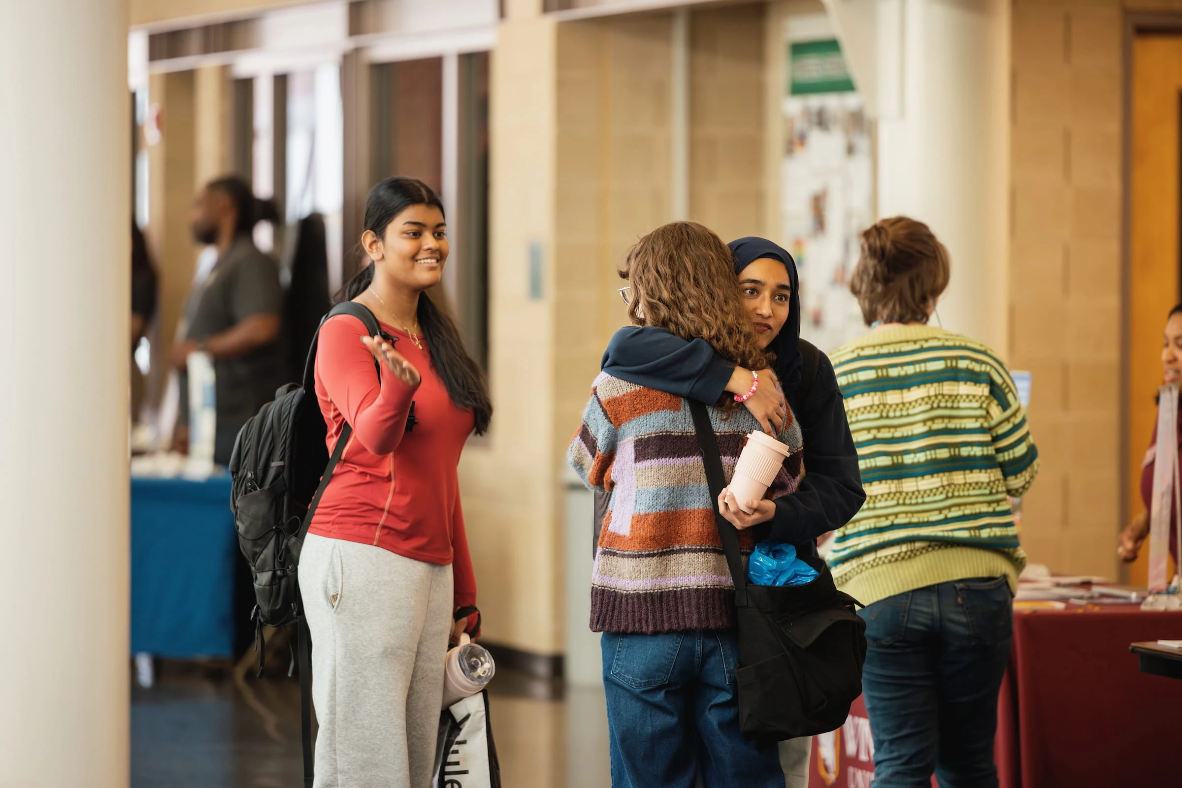 Students talking together in a busy campus corridor